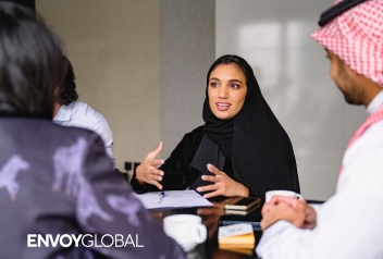Professionals discussing employer compliance with Saudization and Nitaqat workforce requirements in Saudi Arabia during a collaborative meeting.