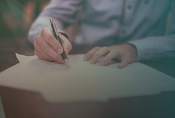 Professional writing on paperwork, illustrating steps in exploring visa alternatives to the H‑1B visa program.